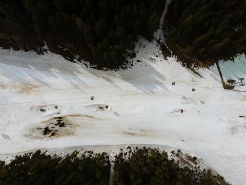 Snow-covered slope in Romania showing ski tracks and equipment set up, highlighting details useful for retail macro specifications and material precision