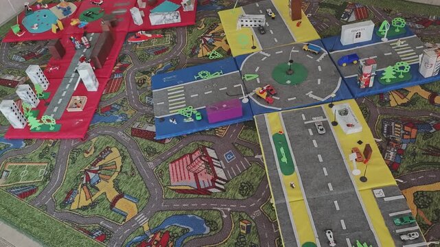 Detailed miniature city with toy cars, buildings, a roundabout, and roads. Children's educational play set simulating urban traffic flow