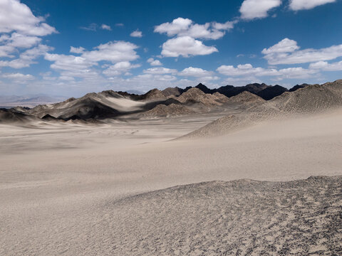 vast desert landscape with rolling mountains under blue sky at heidushan