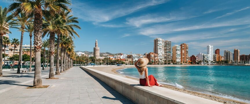Woman sitting on promenade overlooking benidorm beach