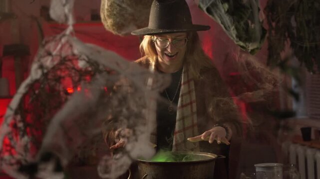 A realistic witch brewing a potion. She waves her hands over the cauldron and recites a spell. Everyday life and traditional witchcraft. Magic and a mystical atmosphere.