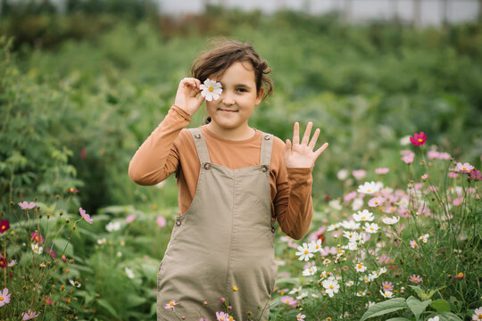 Girl hold flower in summer garden