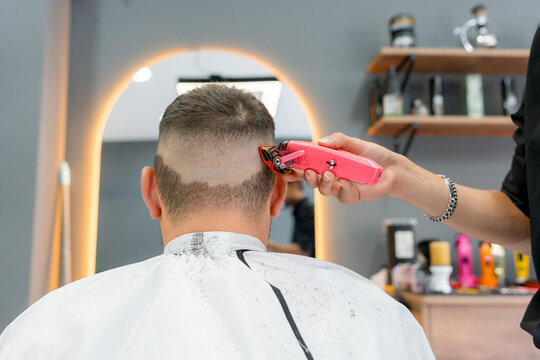 Barber use pink clipper for men's fade haircut