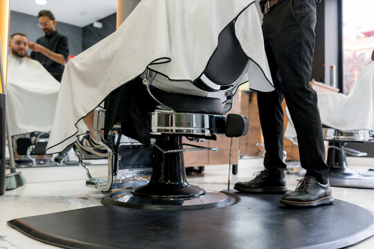 Low angle view of barber cutting client hair in barbershop