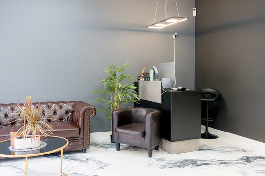 Modern barbershop reception area with leather seating and plants