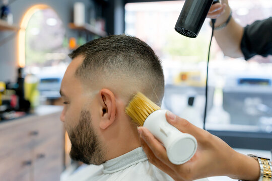Barber blow dry men's fade haircut in barbershop