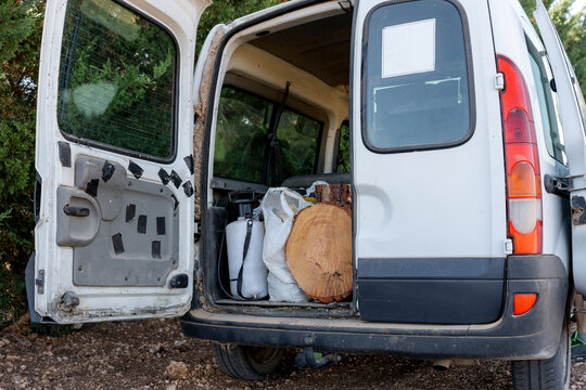 Open cargo van loaded with firewood and sack outdoors