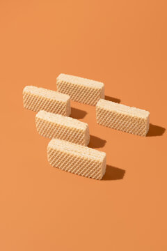 Cream-filled wafer cookie assortment on orange background