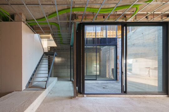 Interior construction site with staircase and glass entrance