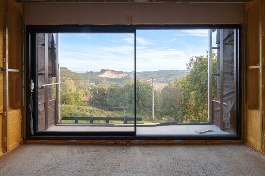 Large window installation in unfinished house construction