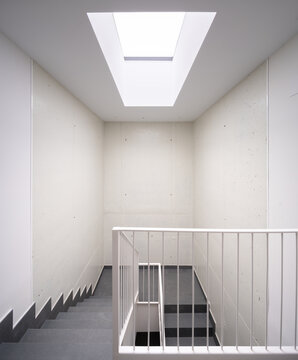 Modern hillside residence stairwell with skylight and railing