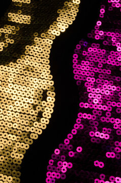 Gold and purple sequin pattern on black textile background