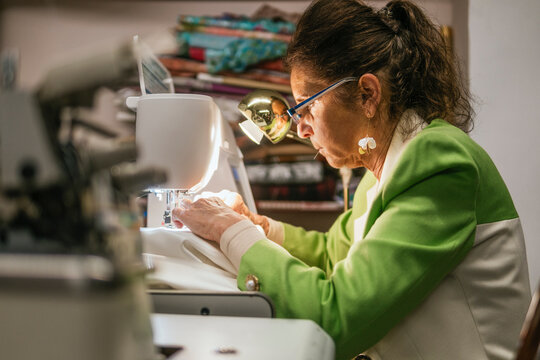 Dressmaker sew handmade garment in workshop with machine