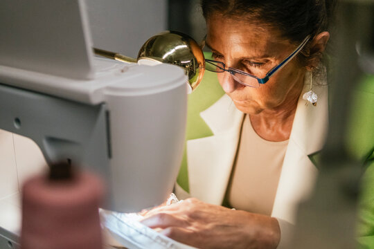 Senior dressmaker sew handmade garment in workshop