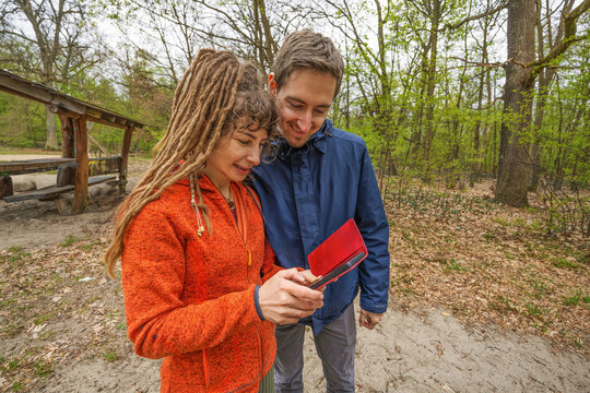 Couple spend time together in park with smartphone