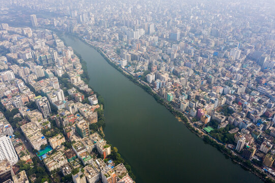 Aerial view of the dense urban landscape of Gulshan 2, featuring high-rise buildings and residential rooftops flanking the calm waters of Gulshan Lake in Dhaka, Dhaka Division, Bangladesh.
