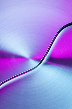 Iridescent metallic abstract texture with curved reflective line