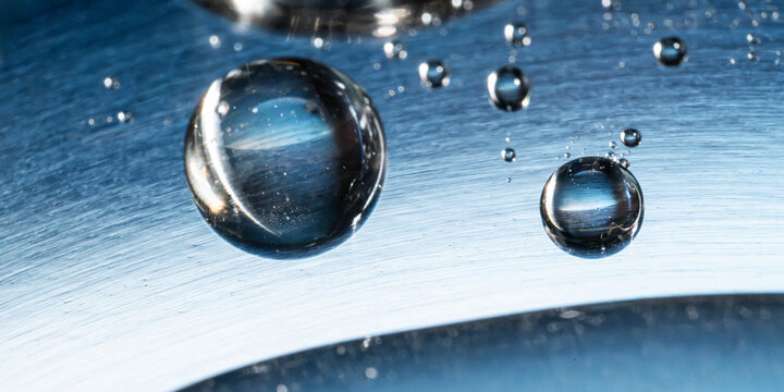 Water droplet on metallic tech background with reflection