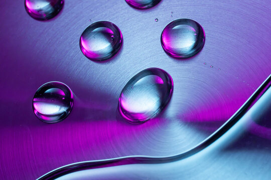 Water droplet on iridescent metallic tech background