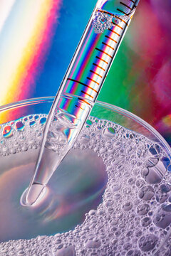 Macro pipette and petri dish with iridescent bubbles
