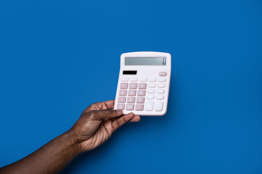 Black man hand hold calculator on blue background
