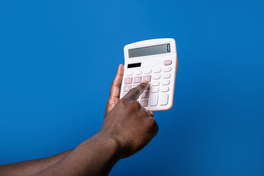 Black man hand use calculator against blue background