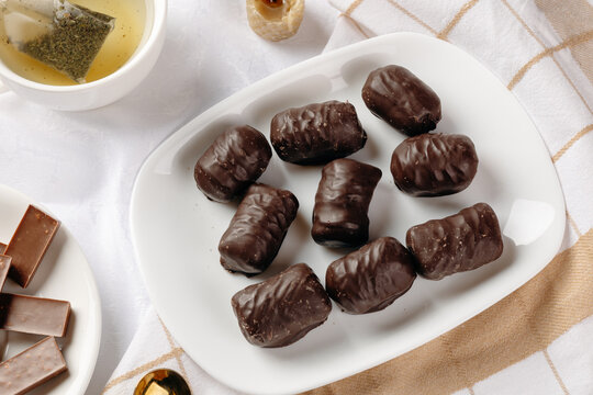 Herbal tea and chocolate sweet on striped textile background