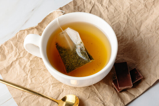 Herbal tea bag infusion with honey in white cup