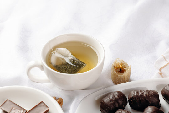 Herbal tea with honeycomb candle and dark chocolate sweets
