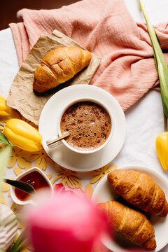 Cozy breakfast with coffee, croissant, bread and tulip