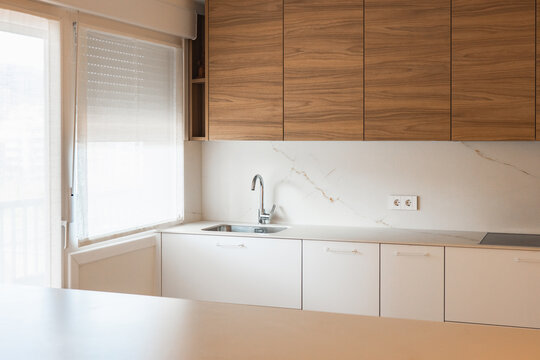 Modern apartment kitchen with wood cabinet and marble backsplash