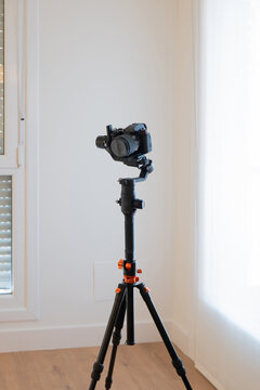 Camera on tripod in modern apartment interior