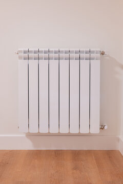 White radiator in modern apartment interior with wood floor