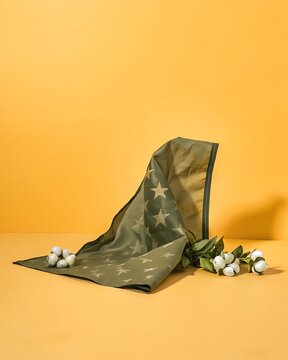 Green fabric scarf with star pattern and small white flowers on a bright yellow background