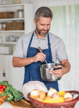 Man holding tasty baked turkey. Thanksgiving day celebration. Hispanic man cooking in kitchen. Thanksgiving dinner food. Man cooking food. Cooking turkey for Thanksgiving. Autumn feast