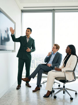 Executive presents business chart to colleagues in office