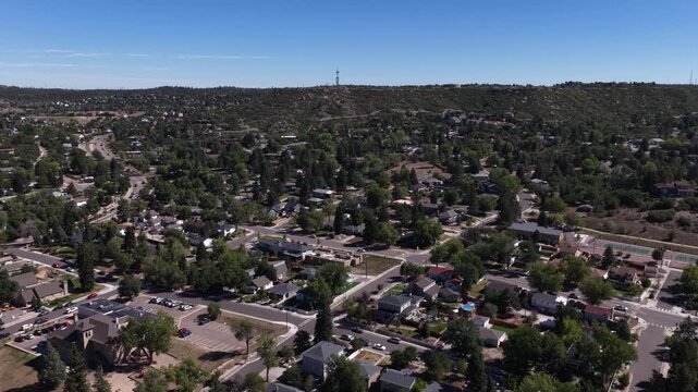 Aerial of suburban neighborhood in Castle Rock Colorado in summer with forest backdrop showing numerous single family homes