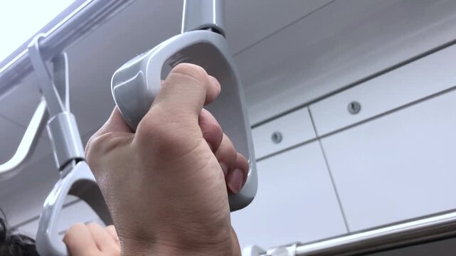 Seoul, South Korea - Jul 2 2024 : Passenger holds a hand strap inside a moving subway train.
