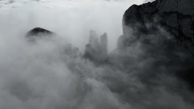 Aerial view of Punta Carina peaks above clouds, Italy.