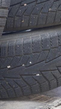 Pile of tires with visible winter profile demonstrates traction. Autumn serves as key season for tire replacement. Early change secures road safety and prevents winter accidents