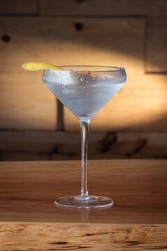 The classic Vesper Martini, served in a modern coupe glass on a wooden background.