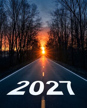 Sunset Highway Road Framed by Dark Silhouette Trees with 2027