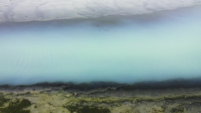 An interesting natural phenomenon. A gray-hydrogen milky stream with dead, bare shores. Crimean salty steppe and seaside. Dead water