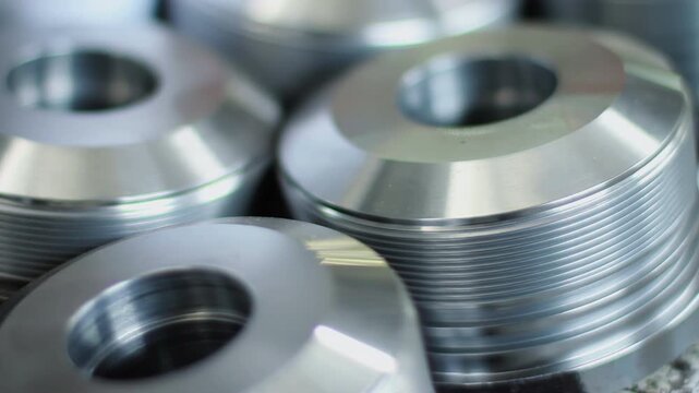 Aluminum pulley wheels stacked factory. Close up shiny grooved machined parts.