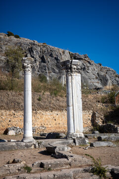Vertical composition highlighting detailed ornate capitals on ancient white marble columns preserved within the historical archaeological UNESCO world heritage site of Philippi.