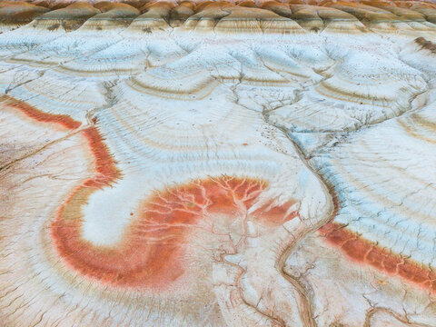 Aerial view of the colorful eroded rock formations and striated clay landscape of the Ustyurt Plateau in Mangistau, Mangystau Region, Kazakhstan.