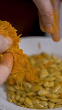 Pumpkin seed on plate. Female hand of housewife evaluates seed. Organic harvest, natural texture, and farming concept