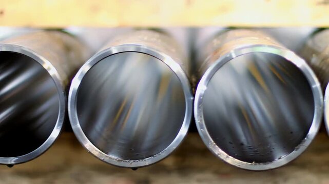 Polished seamless steel pipe row. Close up metal tube end factory warehouse.