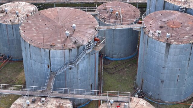 Aerial view of industrial storage tanks with rusted roofs and metal catwalks in an industrial facility in Tbilisi, Tbilisi, Georgia.