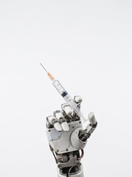 Robotic hand holding a medical syringe with needle against a white background symbolizing future healthcare and automation